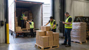 Warehouse team unloading, palletizing, and counting cartons from a shipping container at a Mississauga receiving dock.